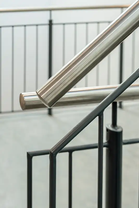 Minimalistisches Treppengeländer aus Edelstahl im Treppenhaus eines Gewerbebaus.