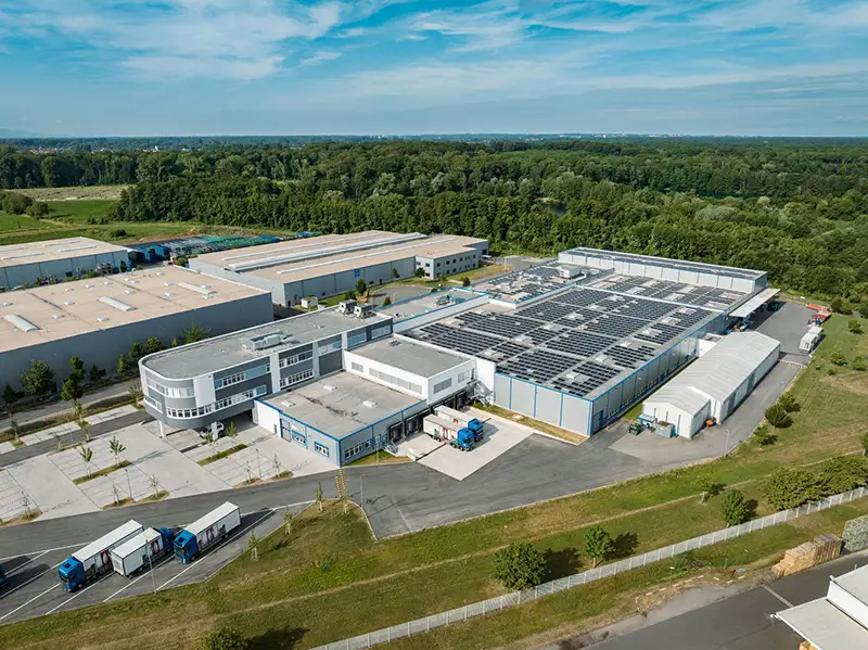 Luftbild einer modernen Industrieanlage und Gewerbehallen im grünen Umfeld – PUR Projektbau.