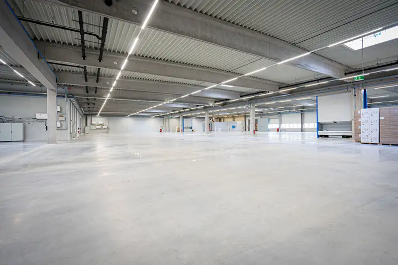 Innenansicht einer riesigen, bezugsfertigen Montagehalle für Gewerbe und Industrie.