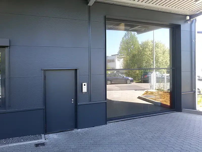 Eingang zu einem modernen Büro- oder Industriegebäude mit anthrazitfarbener Wand.