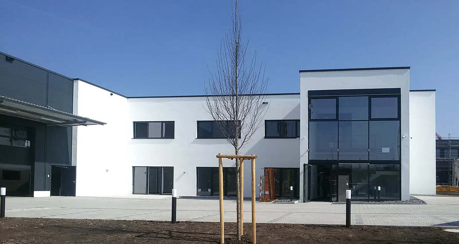 Ansicht eines hellen Bürogebäudes mit Blick auf den gestalteten Innenhofbereich.
