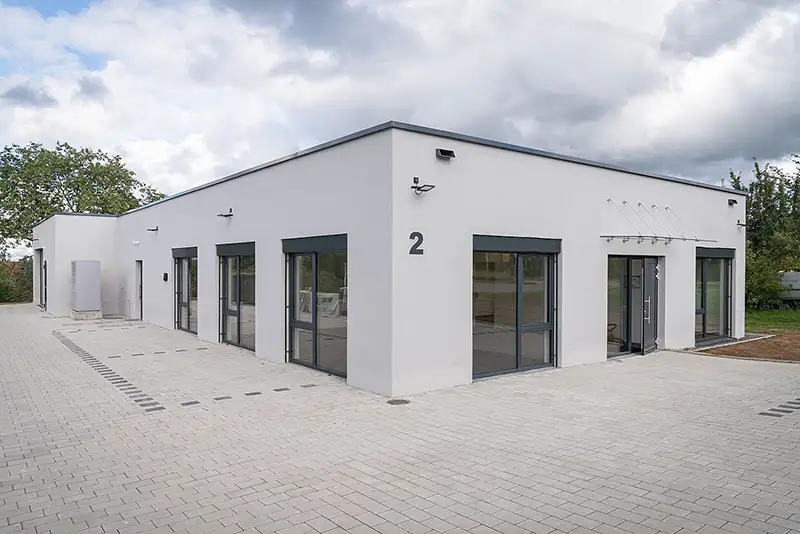Außenansicht eines einstöckigen Gewerbebaus mit großen Glasfronten von PUR Projektbau.