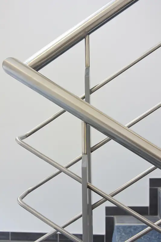 Detailaufnahme eines Edelstahl-Schutzgeländers in einer Industriehalle von PUR Projektbau.