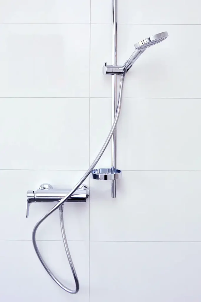 Modern gefliestes Badezimmer mit Dusche in einem Industriegebäude für Mitarbeiter.