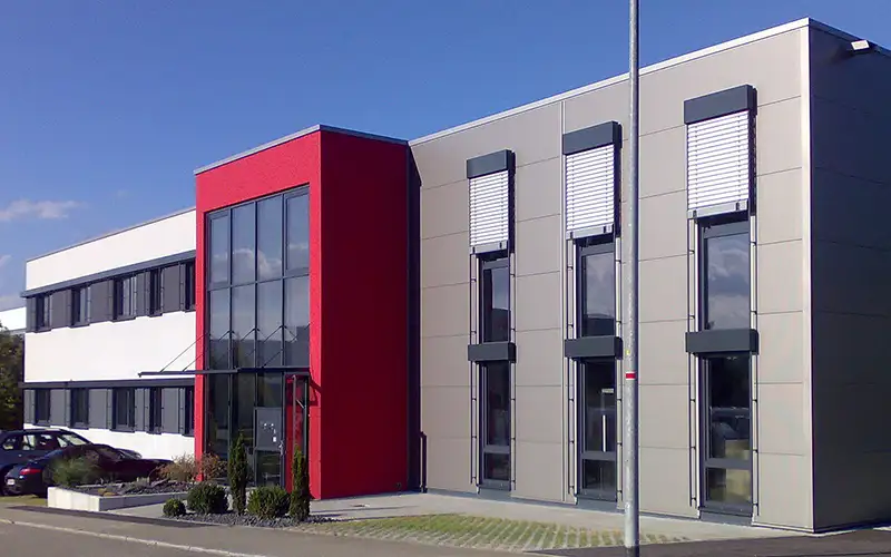 Architektur-Detail eines modernen Industrie- und Gewerbebaus mit grauer Fassade.