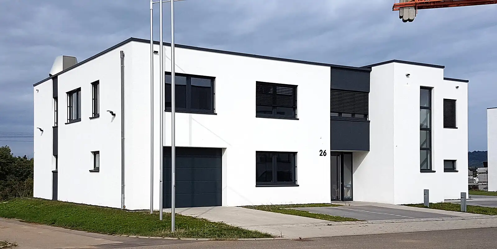 ußenfassade eines zweistöckigen Büro- oder Wohngebäudes in modernem Weiß-Grau-Design.