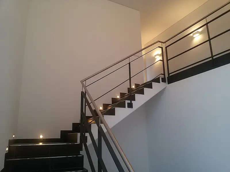 Innenansicht eines modernen, hellen Treppenhauses aus Beton und Edelstahl in einem Gewerbebau.