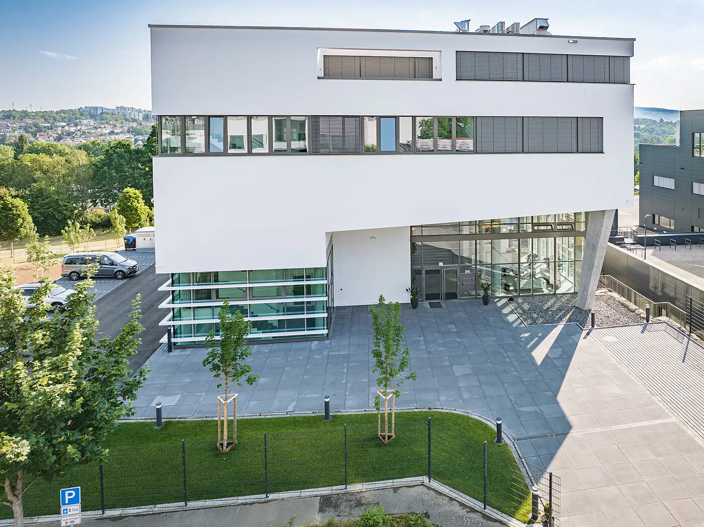 Frontale Außenansicht eines minimalistischen, weißen Gewerbe-Gebäudes von PUR Projektbau.