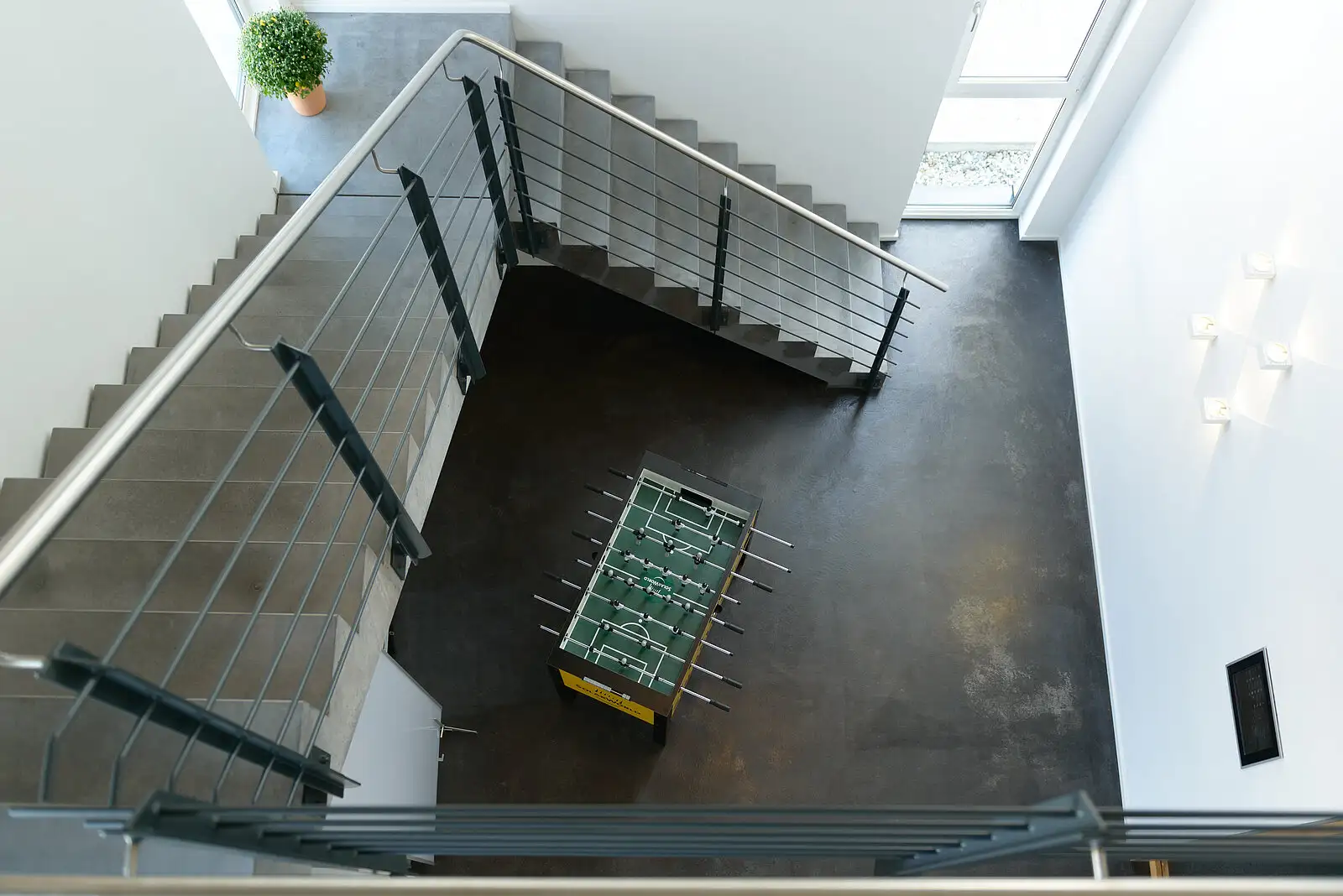 Blick von oben in ein offenes, helles Treppenhaus mit Betonelementen im Bürogebäude.