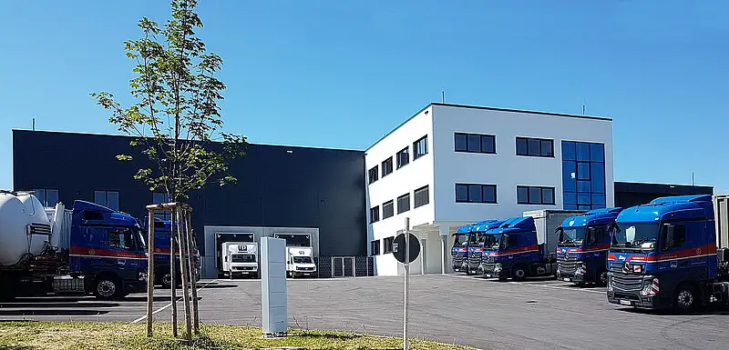 Lkw-Wasch- und Siloreinigungsanlage mit großem Vorplatz und parkenden Nutzfahrzeugen von PUR Projektbau.