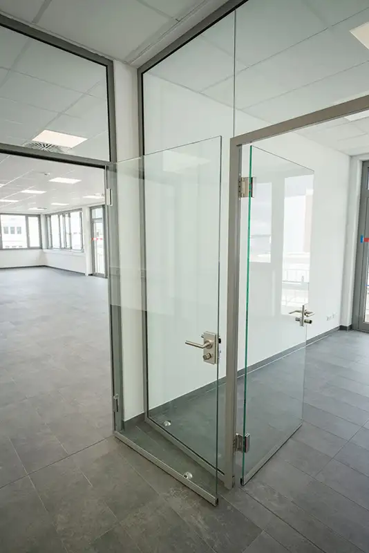 Moderner Flur mit Trennwänden aus Glas in einem Industrie- oder Gewerbe-Gebäude.