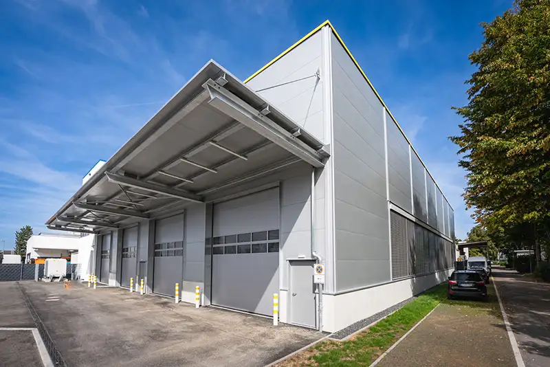 Außenansicht einer modernen Logistik- und Industriehalle mit großem Rolltor von PUR Projektbau.