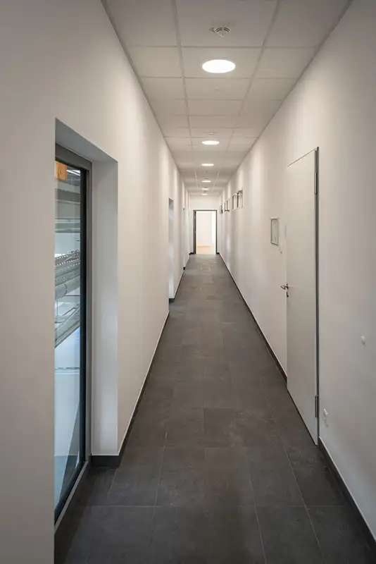 Minimalistischer, heller Gang mit LED-Beleuchtung in einem von PUR Projektbau fertiggestellten Objekt.