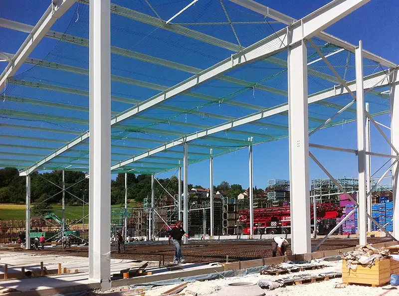 Im Bau befindliche Industriehalle mit sichtbarer Stahlbau-Skelettkonstruktion.