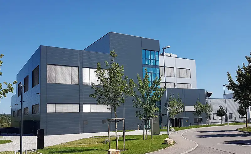 Modernes Gewerbegebäude mit dunkelgrauer Fassadengestaltung und Fenstern.