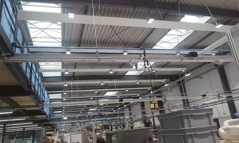 Innenansicht einer großen Industriehalle mit sichtbarer Deckenkonstruktion während des Baus.